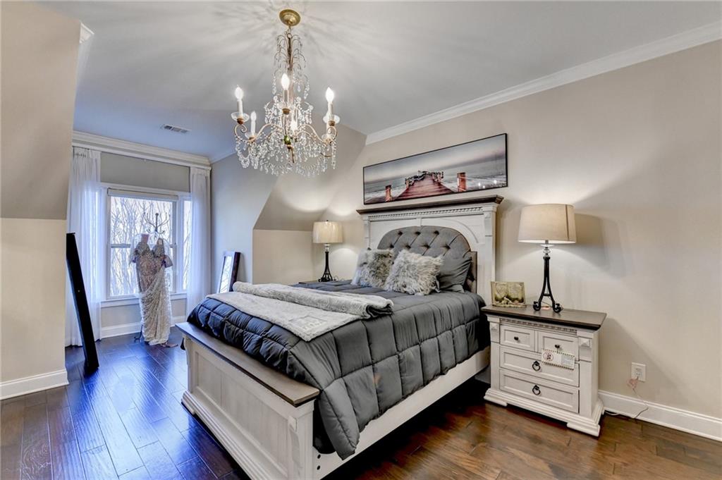 8360 Kenningston Way Duluth, GA 30097 - Photo 37 of 54 a bedroom with a bed and a chandelier