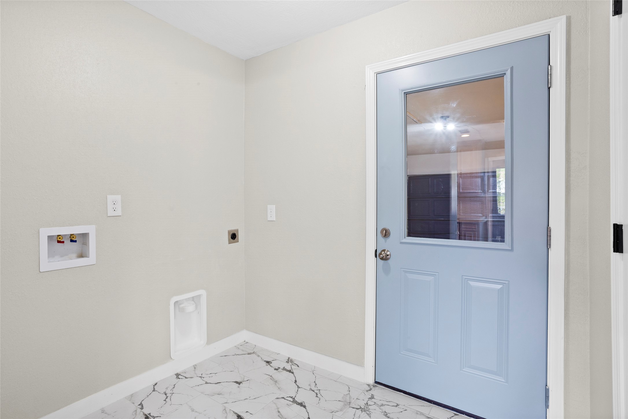 10127 Tolman Street Houston, TX 77034 - Photo 22 of 27 This utility room provides a clean, functional workspace that maintains the home's modern, light-filled aesthetic.