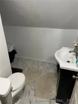 a white toilet sitting next to a bathroom sink