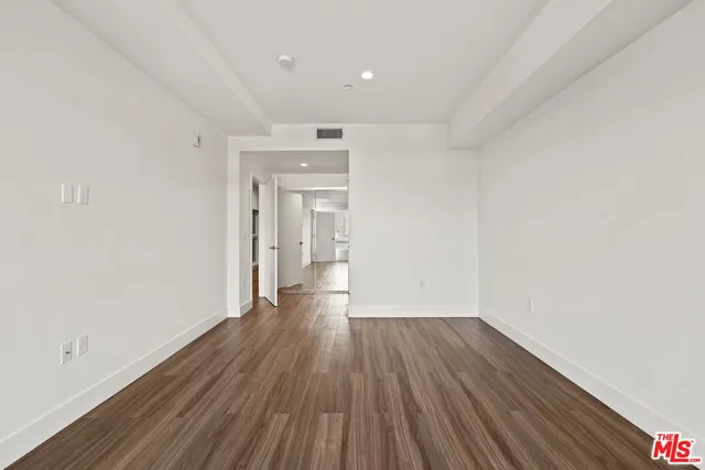 a view of a room with wooden floor and a hallway