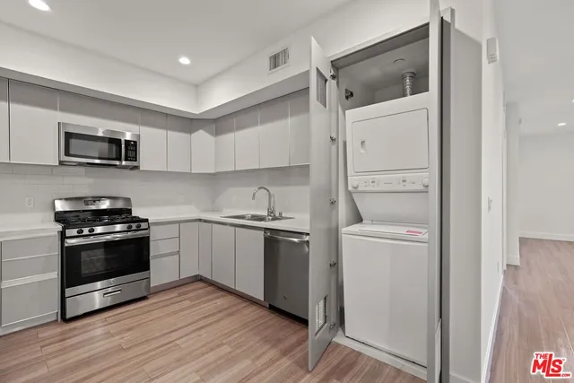 a kitchen with stainless steel appliances a stove microwave and sink