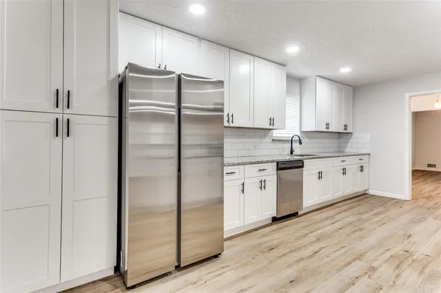 a kitchen with stainless steel appliances granite countertop a refrigerator and a stove top oven