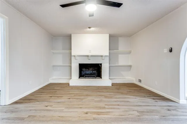 a view of an empty room with a fireplace and a window
