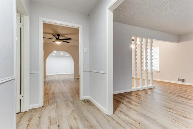 an empty room with wooden floor cabinet and windows