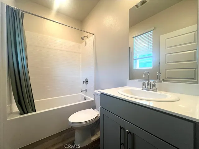 a bathroom with a sink a toilet a mirror and shower