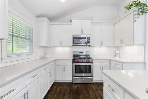 a kitchen with stainless steel appliances a white stove top oven and a sink