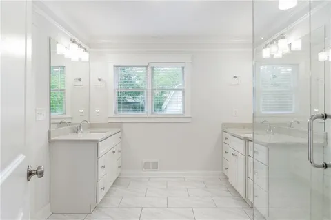 a spacious bathroom with double vanity and a mirror