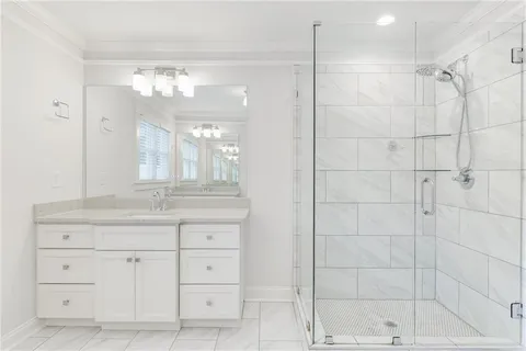 a bathroom with a granite countertop sink a shower and a mirror