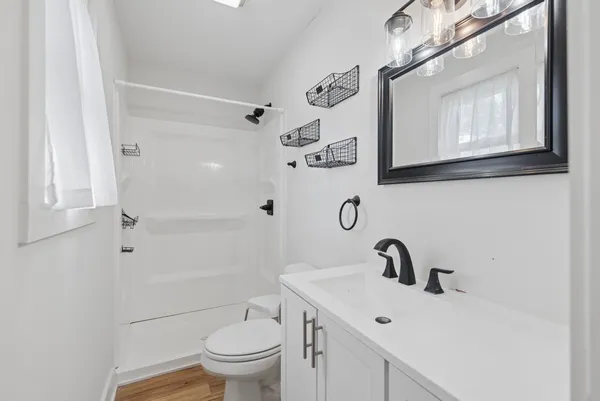 a bathroom with a sink a toilet and shower