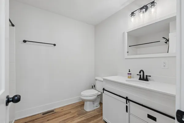 a bathroom with a toilet a sink and mirror