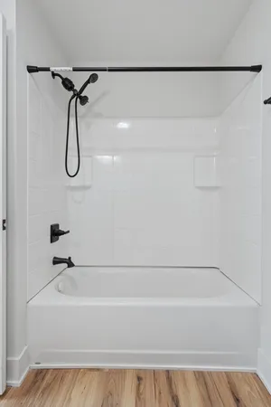 a bathroom with a bath tub with a shower