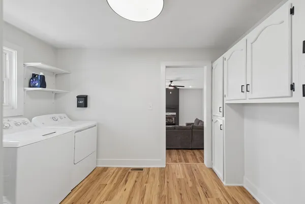 a hallway view with wooden floor and electronic appliances