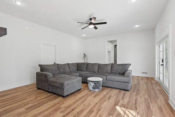 a living room with furniture and a wooden floor