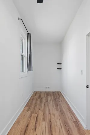 a view of a room with wooden floor and a window