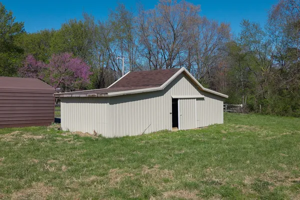a view of a house with a yard and fence