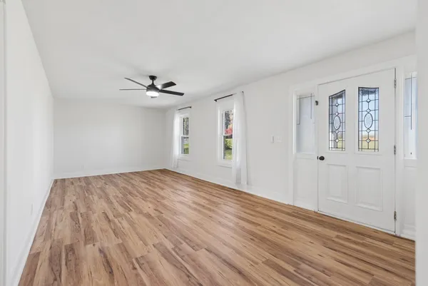 a view of a livingroom with wooden floor and a ceiling fan