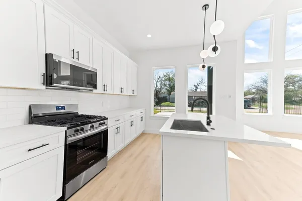 a kitchen with granite countertop a sink and a stove top oven