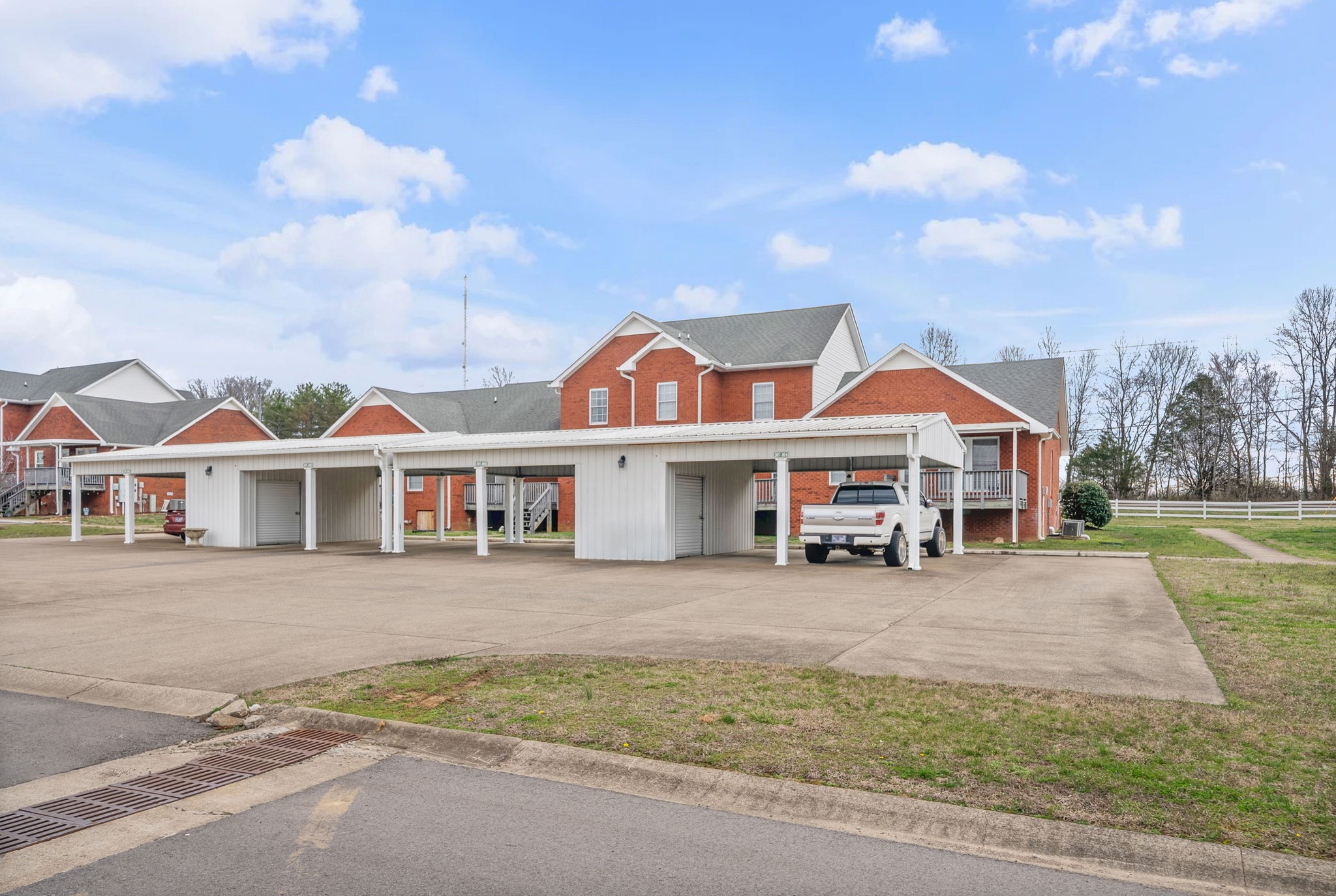 207 Bailey Lane, Unit 102 Pleasant View, TN 37146 - Photo 30 of 30 a view of a white house with a big yard and large trees