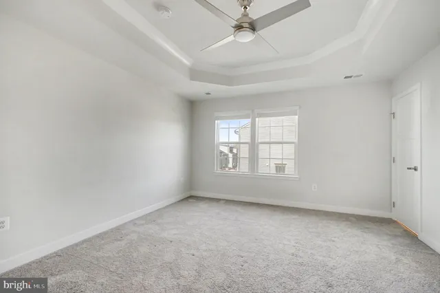 an empty room with a window and ceiling fan