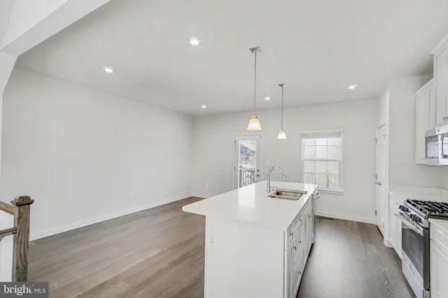 a kitchen with a sink a stove a refrigerator and a window