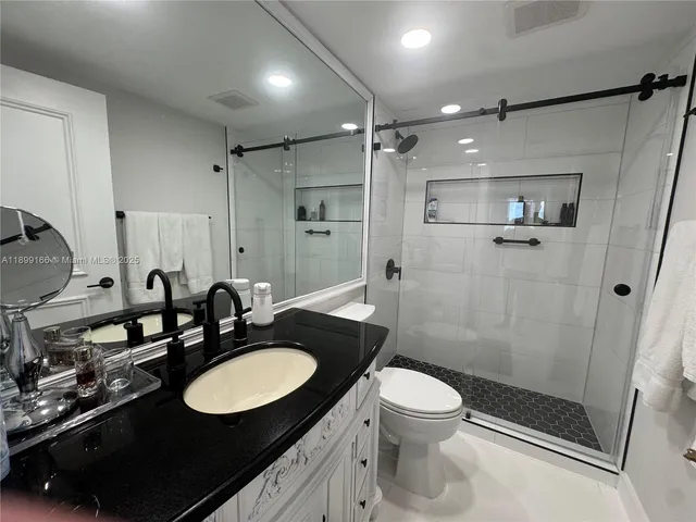 a bathroom with a sink a toilet and shower