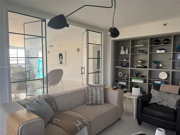 a living room with furniture a window and a chandelier