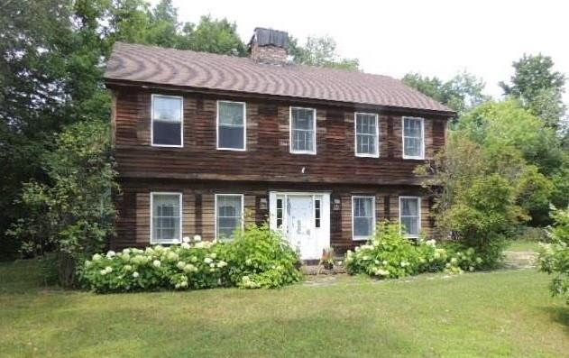 a front view of a house with a garden