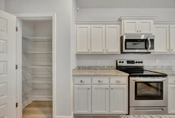 a kitchen with white cabinets and stainless steel appliances