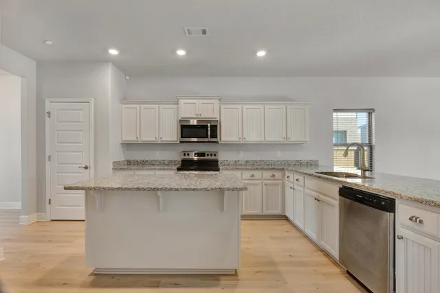 a kitchen with granite countertop a stove and a sink