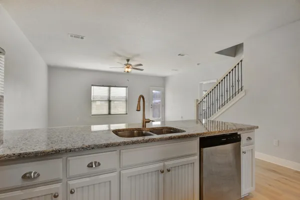 a kitchen with granite countertop a sink a stove and cabinets