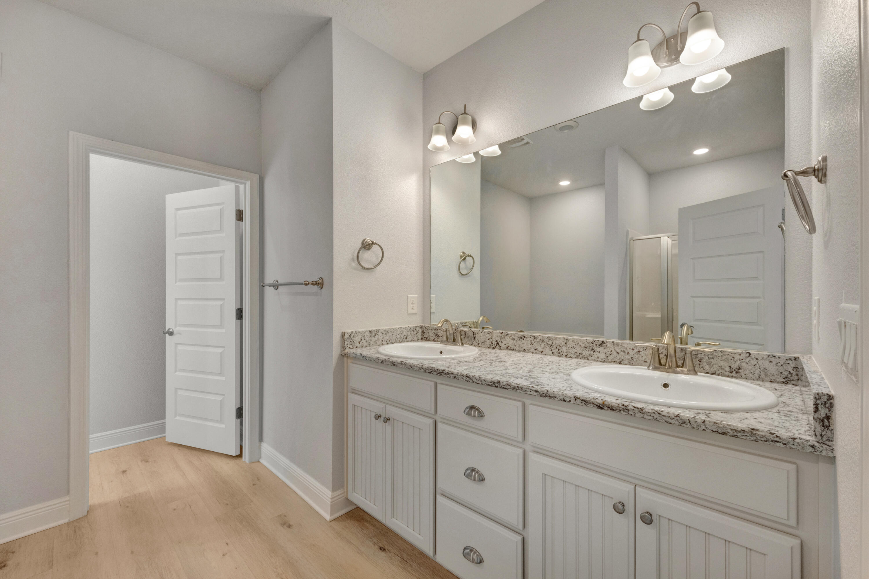 231 Baycliff Drive Crestview, FL 32536 - Photo 19 of 49 a bathroom with a granite countertop double vanity sink a mirror and a shower