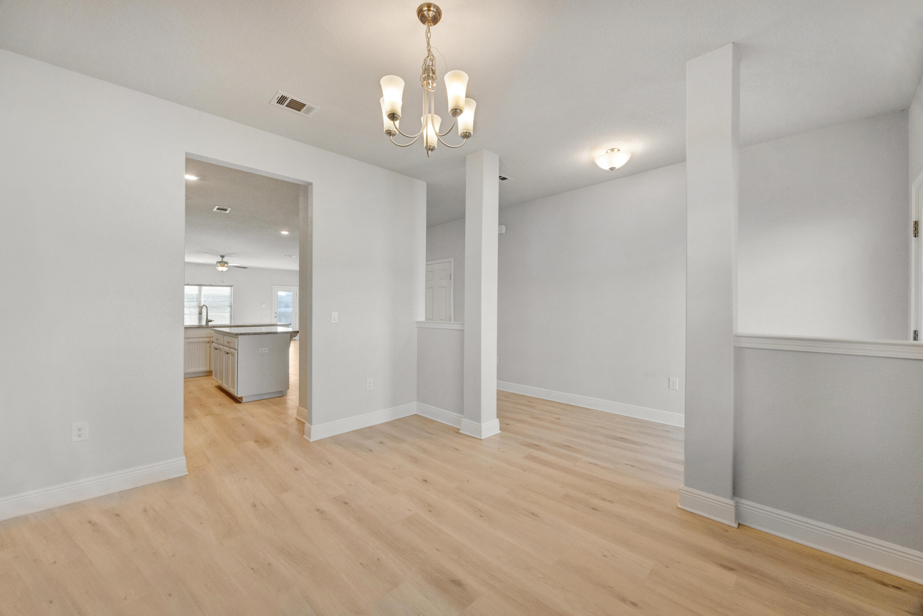 231 Baycliff Drive Crestview, FL 32536 - Photo 6 of 49 a view of a big room with wooden floor and a kitchen
