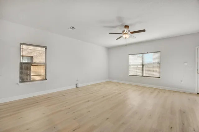 a view of large kitchen with wooden floor and a ceiling fan