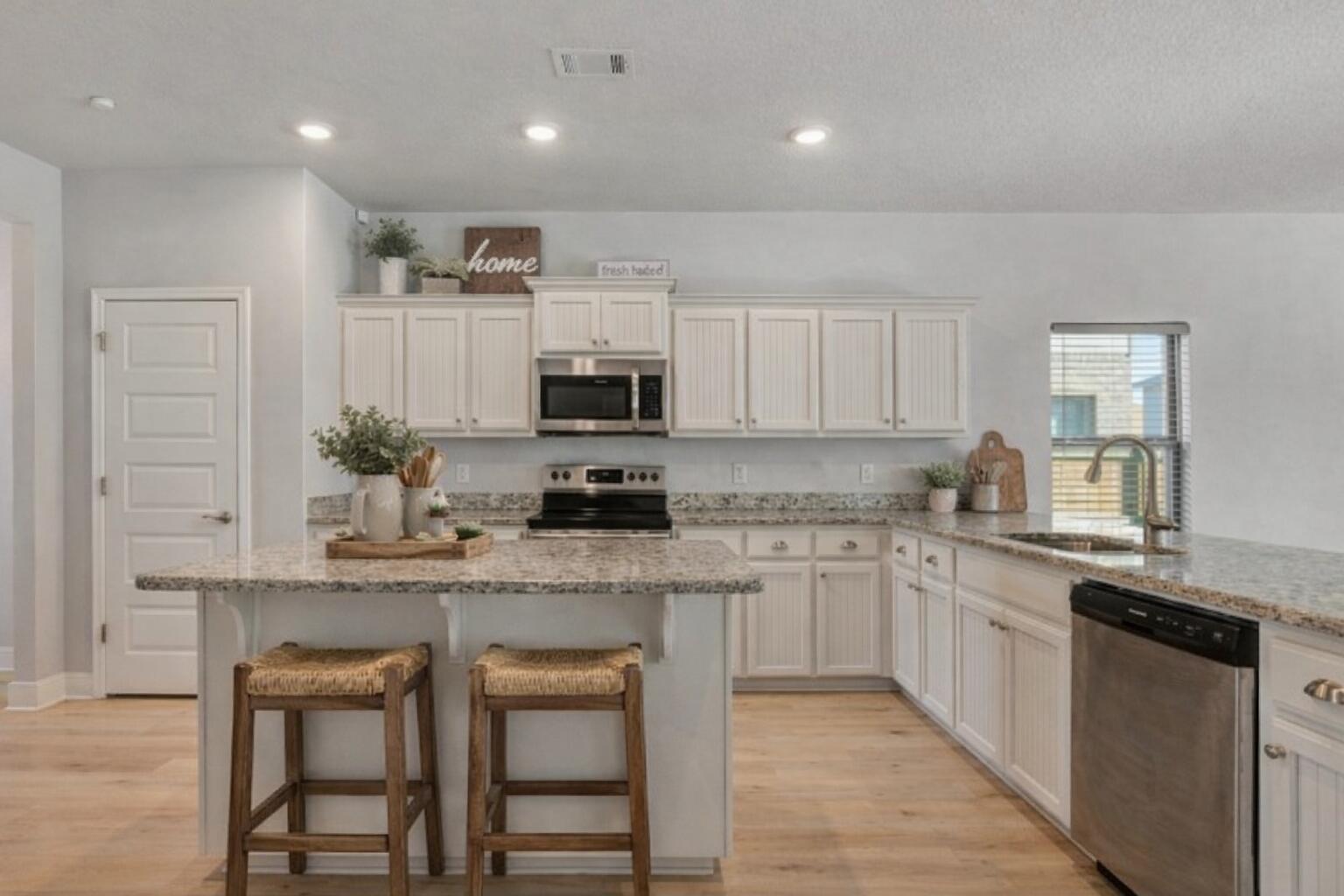 231 Baycliff Drive Crestview, FL 32536 - Photo 8 of 49 a kitchen with kitchen island granite countertop white cabinets and stainless steel appliances