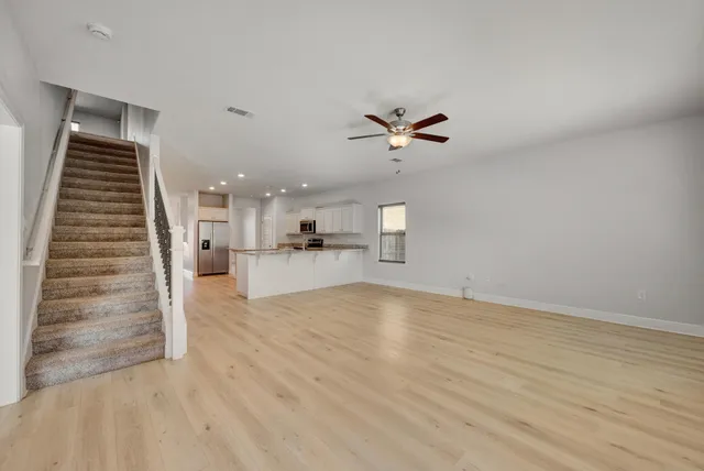 a large kitchen with stainless steel appliances granite countertop a stove a sink and a refrigerator