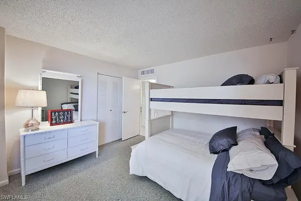 a bedroom with a bed and a closet with mirror