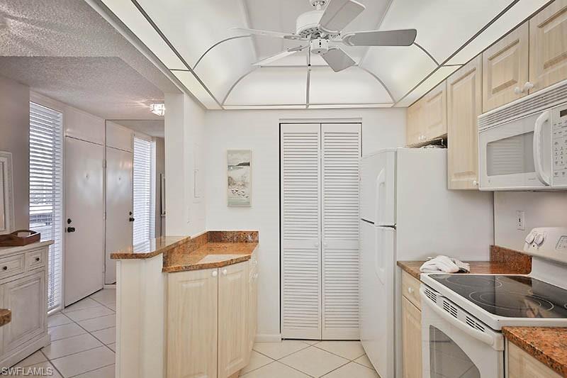 651 Seaview Court, Unit B207 Marco Island, FL 34145 - Photo 5 of 17 a kitchen with stainless steel appliances granite countertop a refrigerator and a sink
