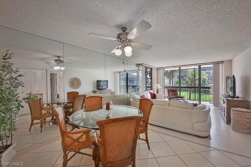 651 Seaview Court, Unit B207 Marco Island, FL 34145 - Photo 8 of 17 a living room with fireplace furniture and a large window