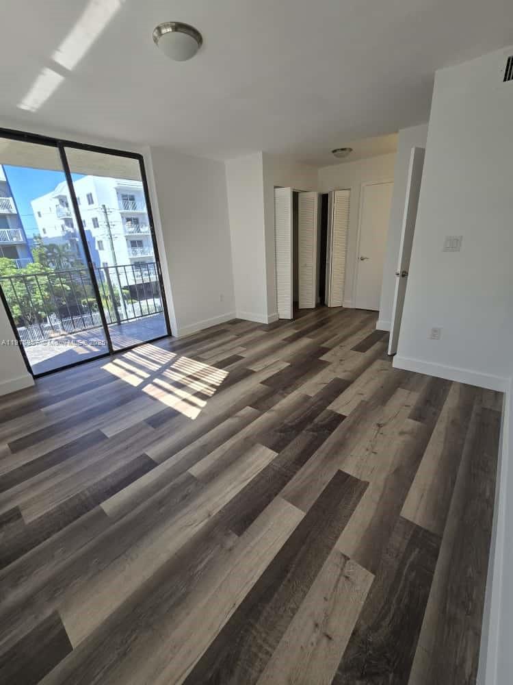 1673 Bay Road, Unit 301 Miami Beach, FL 33139 - Photo 12 of 18 a view of an empty room with wooden floor and a window