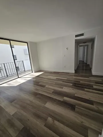 a view of a livingroom with wooden floor and white walls