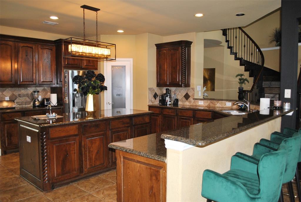 a kitchen with granite countertop a sink a counter top space appliances and cabinets