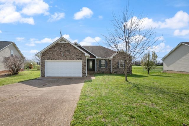 a view of a house with a yard and garage