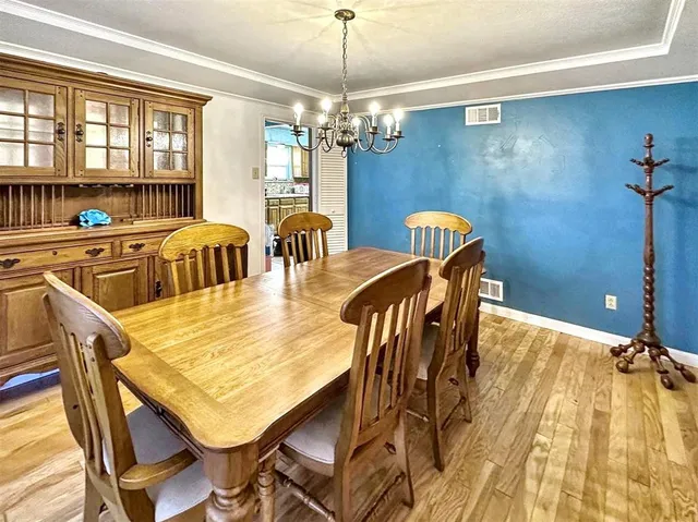 a dining room with furniture a chandelier and wooden floor