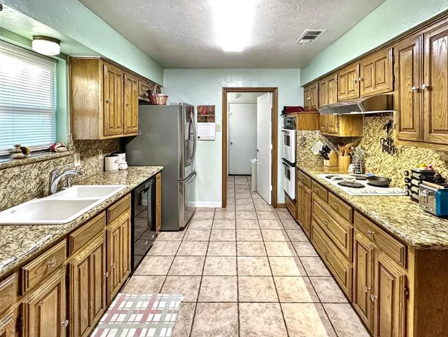 a bathroom with a granite countertop double vanity sink and a large mirror