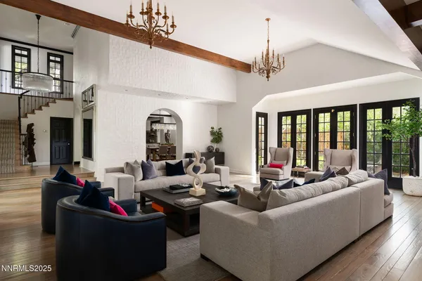 a living room with patio furniture and a chandelier