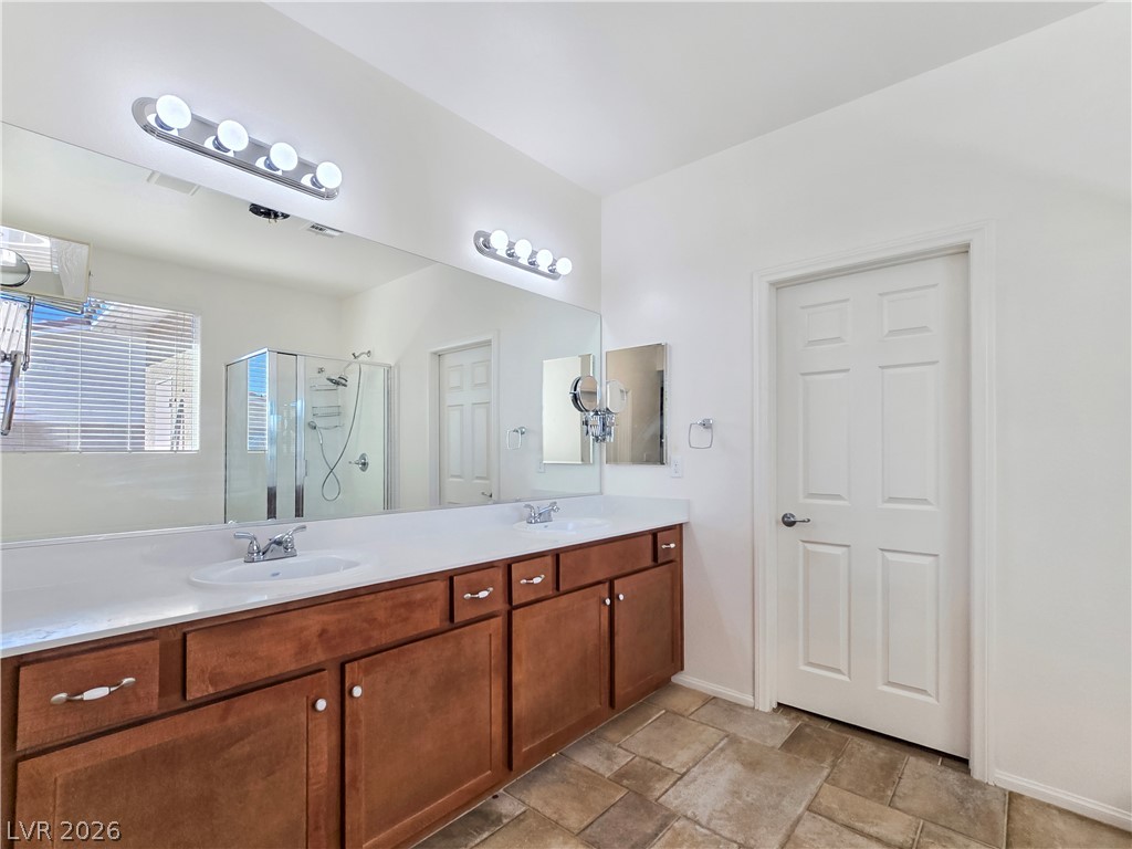 2485 Morrow Ridge Place Laughlin, NV 89029 - Photo 23 of 40 Double vanity with ample counter space and a sleek, glass-enclosed shower.