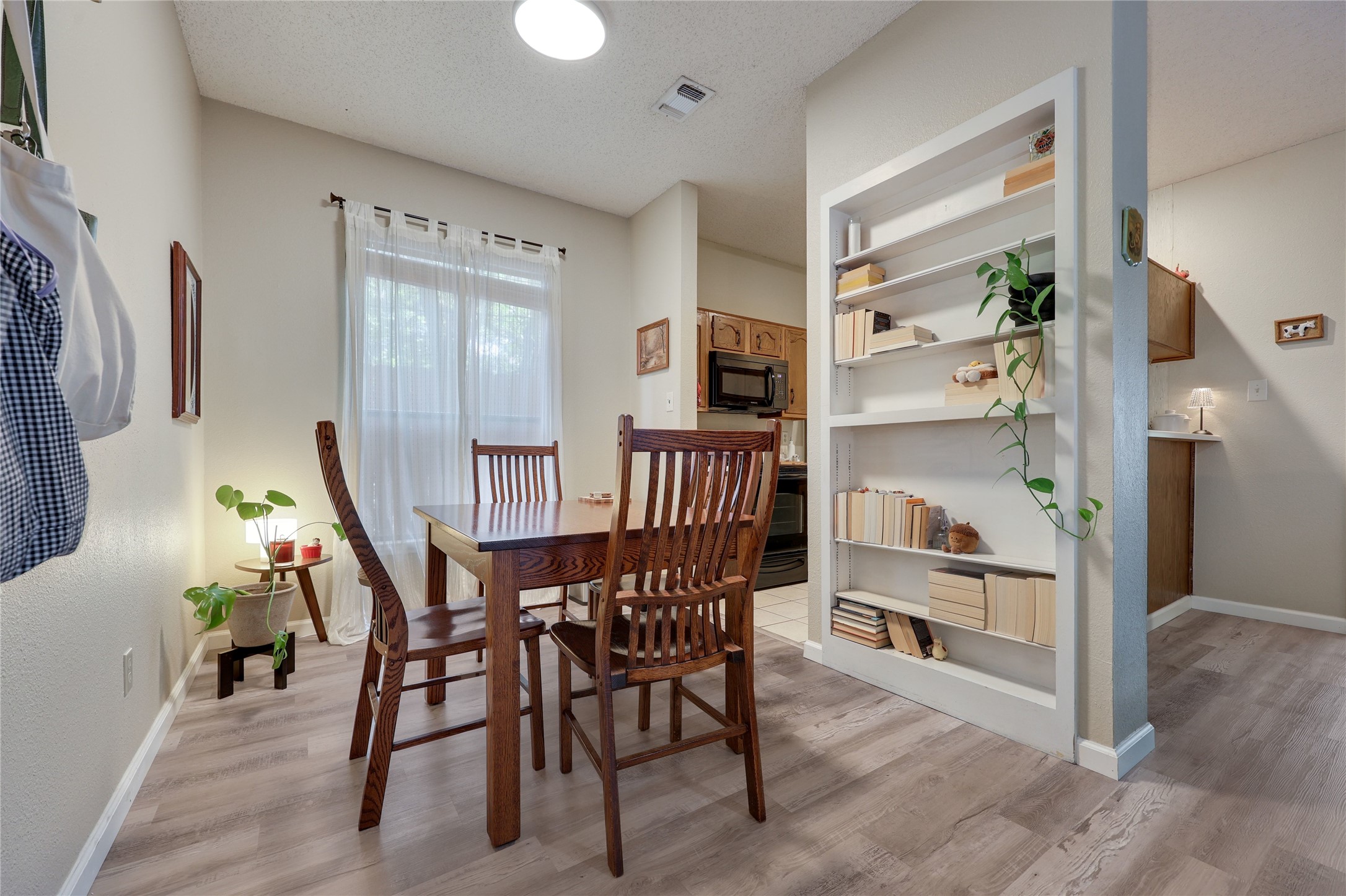 3011 Fruth Street, Unit 101 Austin, TX 78705 - Photo 7 of 14 Natural light illuminates this cozy dining area, featuring stylish built-in shelving.