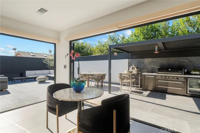 a kitchen with stainless steel appliances kitchen island a large stove a sink and a dining table with the view of kitchen