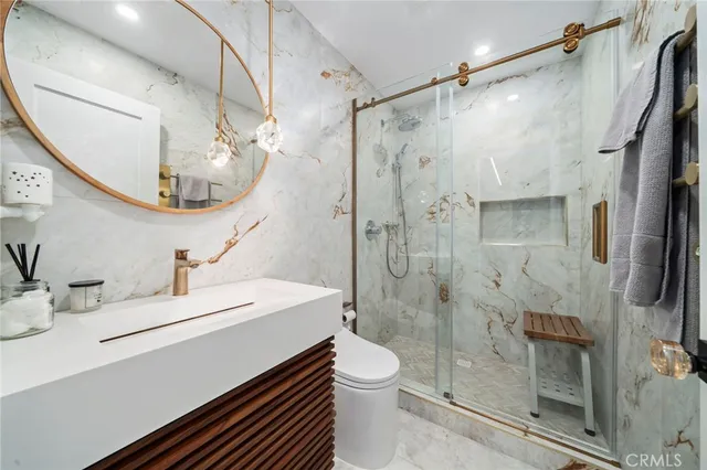 a bathroom with a sink a toilet and shower