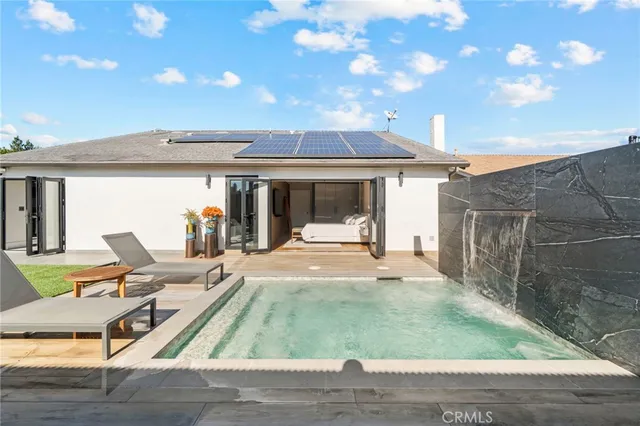 a view of a patio with table and chairs near a barbeque